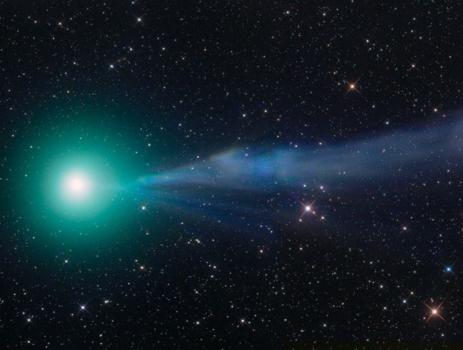 A bright blue-green comet with a blue tail